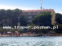 Hotel Ugljan na Wyspie Ugljan w miejscowości Ugljan, położonej naprzeciwko historycznego Zadaru w Chorwacji. Z Zadaru do Ugljan kursuje prom. W Hotelu Ugljan dostępne są pokoje z balkonem od strony morza i balkonem francuskim od strony parku, 2 i 2+1 osobowe z łazienką i WC. Rodziny czteroosobowe i większe też znajdą tutaj możliwość spędzenia wakacji. Natomiast dla zwierzątek domowych należy zaplanować wakacje w innym hotelu. Hotel Ugljan posiada oprócz recepcji i sklepiku z pamiątkami, restaurację, aperitív bar, taras z muzyką i pięknym widokiem na morze. Hotel Ugljan posiada własną plażę, plac zabaw dla dzieci, wypożyczalnie rowerów i sprzętów wodnych, łódek, rowerów wodnych i desek surfingowych. Hotel Ugljan znajduje się przy utwardzonej plaży z leżakami i parasolami słonecznymi, w pobliżu hotelu można korzystać również z plaży żwirowo-piaszczystej doskonałej dla małych dzieci i osób nie posiadających umiejętności pływackich. Mnogość zatoczek, również z plażą piaszczystą i piękno bujnej śródziemnomorskiej przyrody to dodatkowe atuty Ugljan. Tutaj można spotkać drzewa figowe, migdałowe i oliwne oraz uprawy winorośli. Okolice Wyspy Ugljan świetnie nadają się na uprawianie sportów wodnych, żeglarstwa i jachtingu, jazdy na nartach wodnych, flyboardingu, nurkowania i wędkarstwa. Z Hotelu Ugljan można wybrać się na jednodniowe wycieczki do parków narodowych: Kornati, Plitvicke Jeziora, Paklenica i Wodospady Krka.